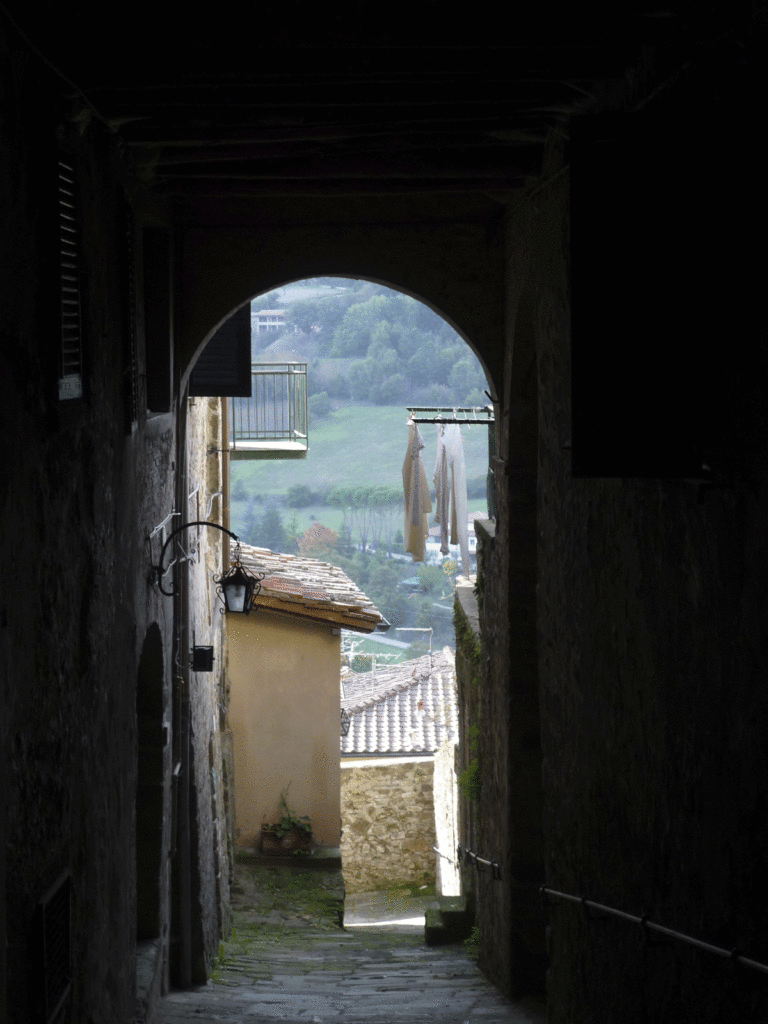 Medieval city gate open to the Tuscan countryside, Poppi, Italy.