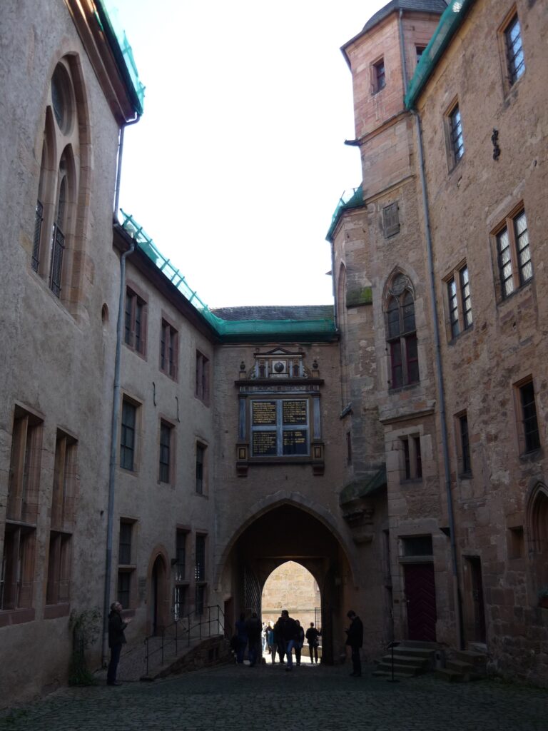 people silhouetted in the archway of a castle