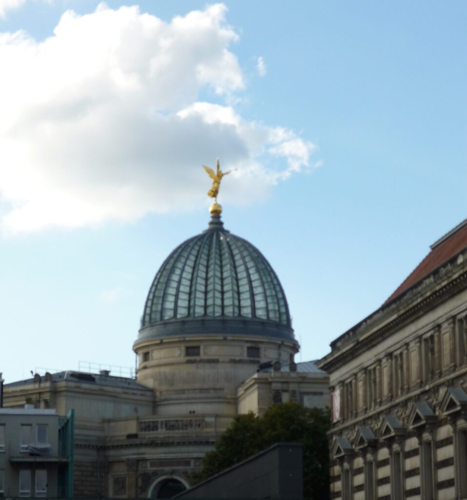 Building with glass dome with gold figure on top