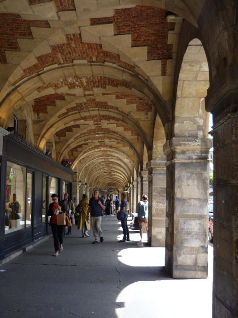 Brick and stone arcade with shops in Paris.