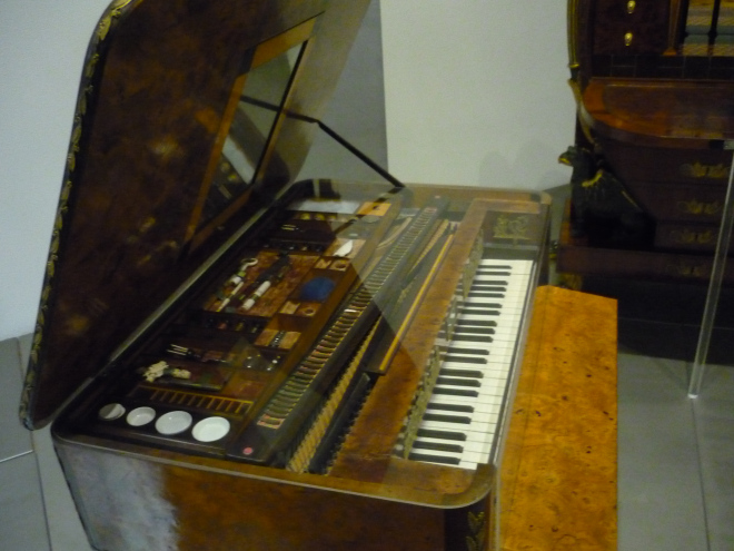 piano with open lid revealing grooming utensils underneath