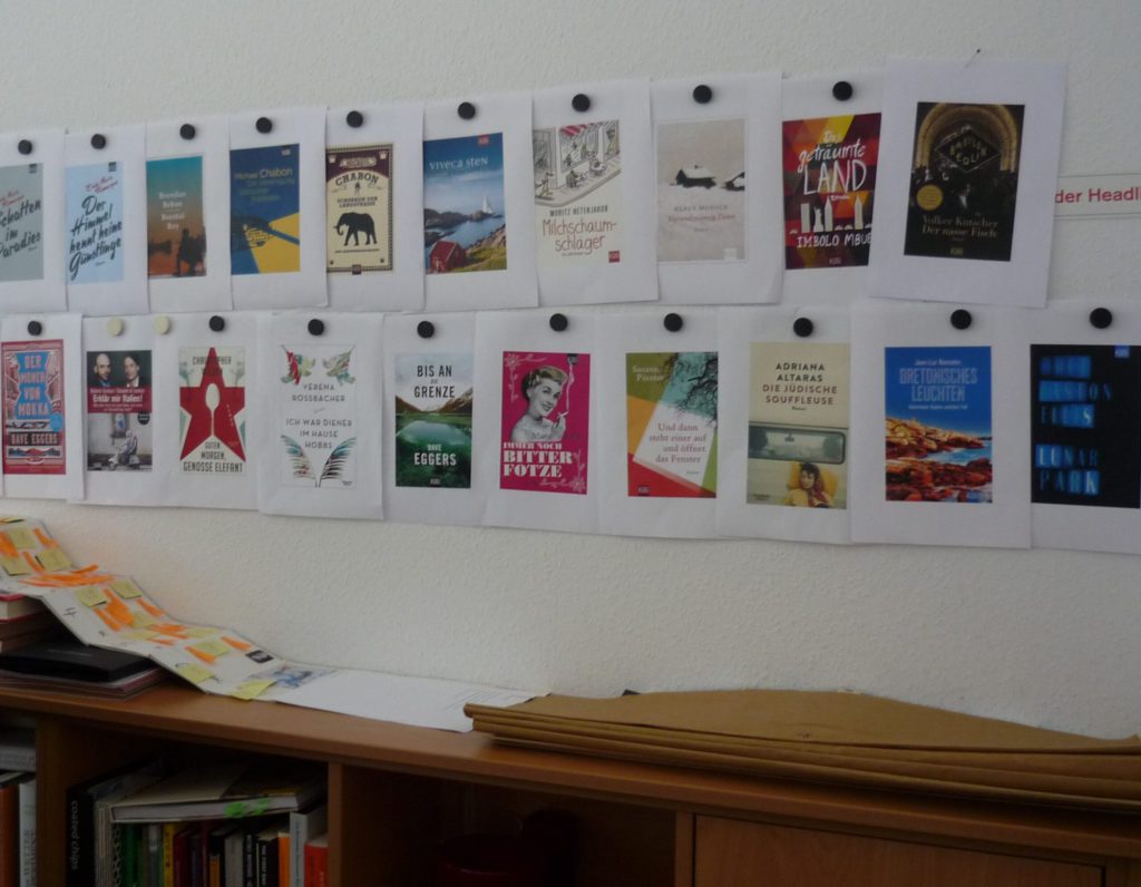 paper printouts of final bookcover designs, put up with fat round magnets