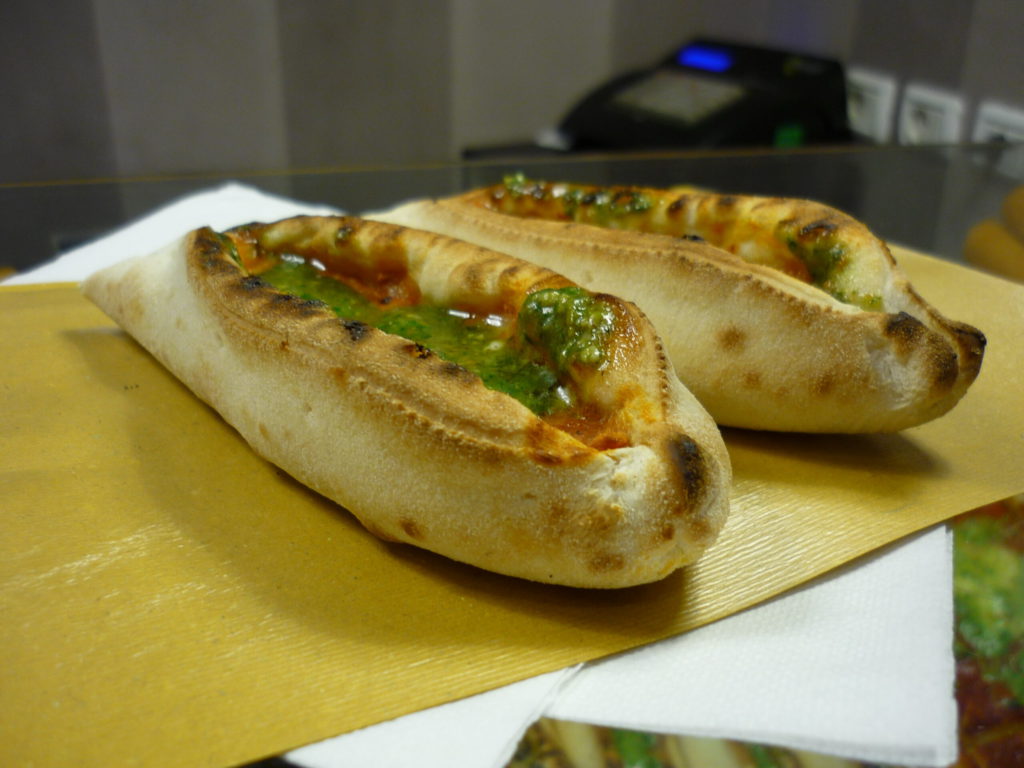 baked boats of bread filled with pesto, tomato sauce and mozzarella.