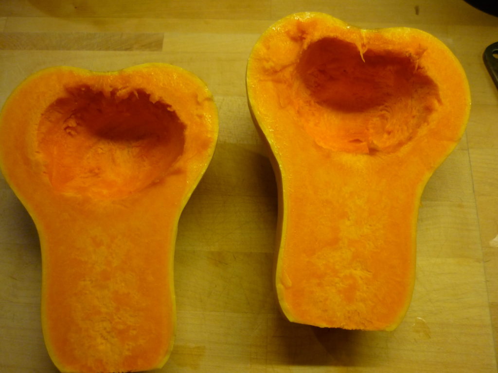 Raw butternut squash halves with seeds removed.