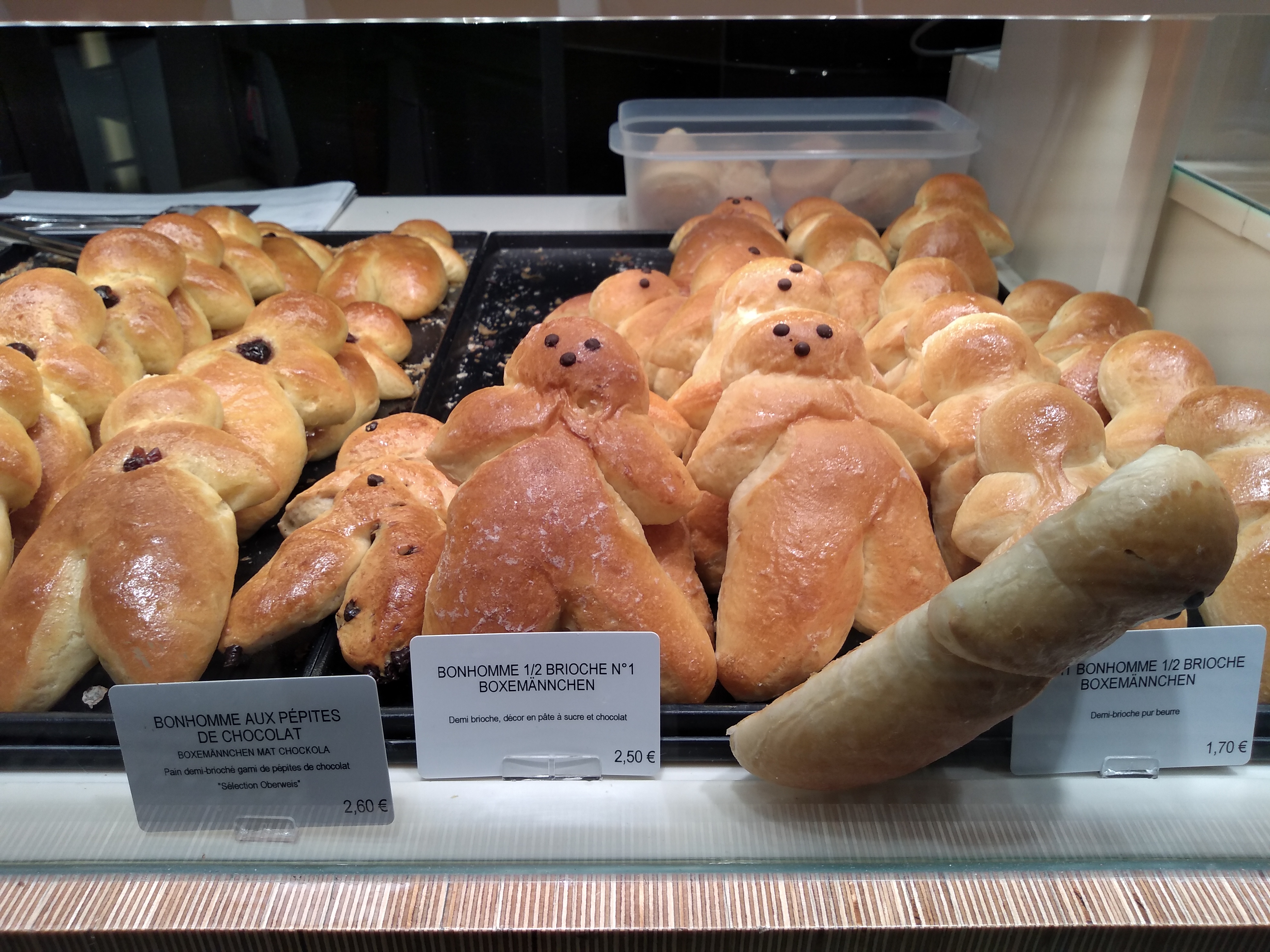 Small bread baked in the shape of gingerbread men in a bakery window