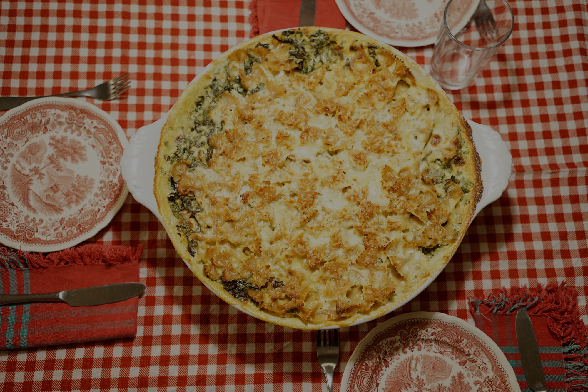 pasta casserole with chiffonaded ruby chard on the edges on checked tablecloth 