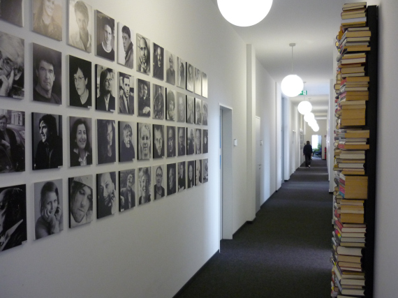 hallway with square portraits lined up in a grid 4 high by more than 10 across