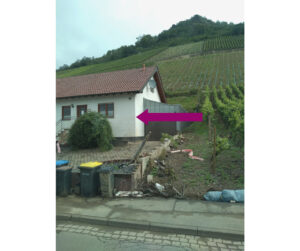 house below vineyards with water line from flooding under the front window