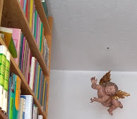 cupid with gilded wings in a bookstore