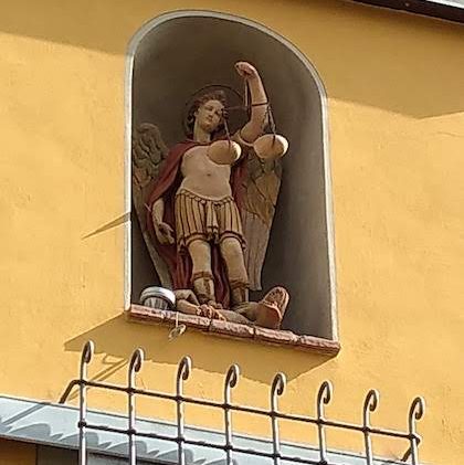 Angel holding scales of justice in a house niche Sienna Italy