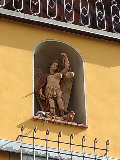 Angel holding scales of justice in a house niche Sienna Italy