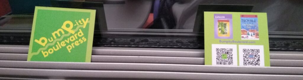 Bumpity business card on vent rails on train window