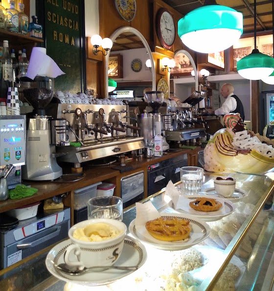 cafe counter with coffees and pastries perched on top of glass vitrine